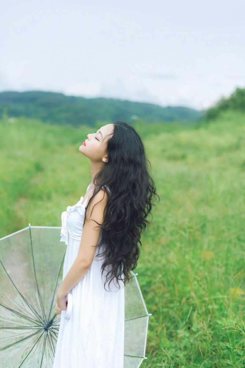 嘴含花气质美女长卷发撑伞白纱裙诱惑户外写真