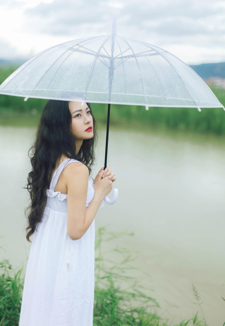 嘴含花气质美女长卷发撑伞白纱裙诱惑户外写真