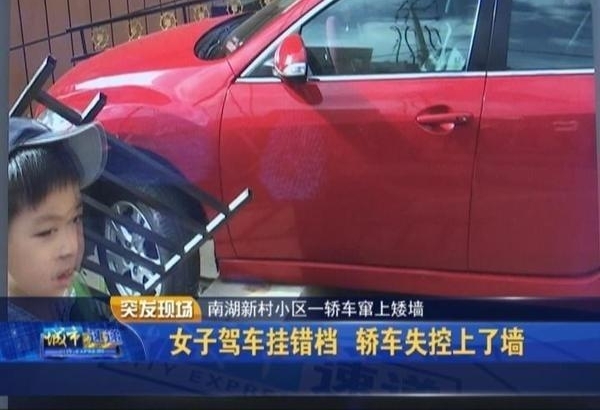 女子驾车挂错挡 轿车失控上了墙