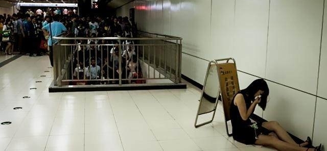 直击北京地铁女子被挤翻白眼，躲在提示板后面默默哭泣