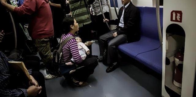 直击北京地铁女子被挤翻白眼，躲在提示板后面默默哭泣